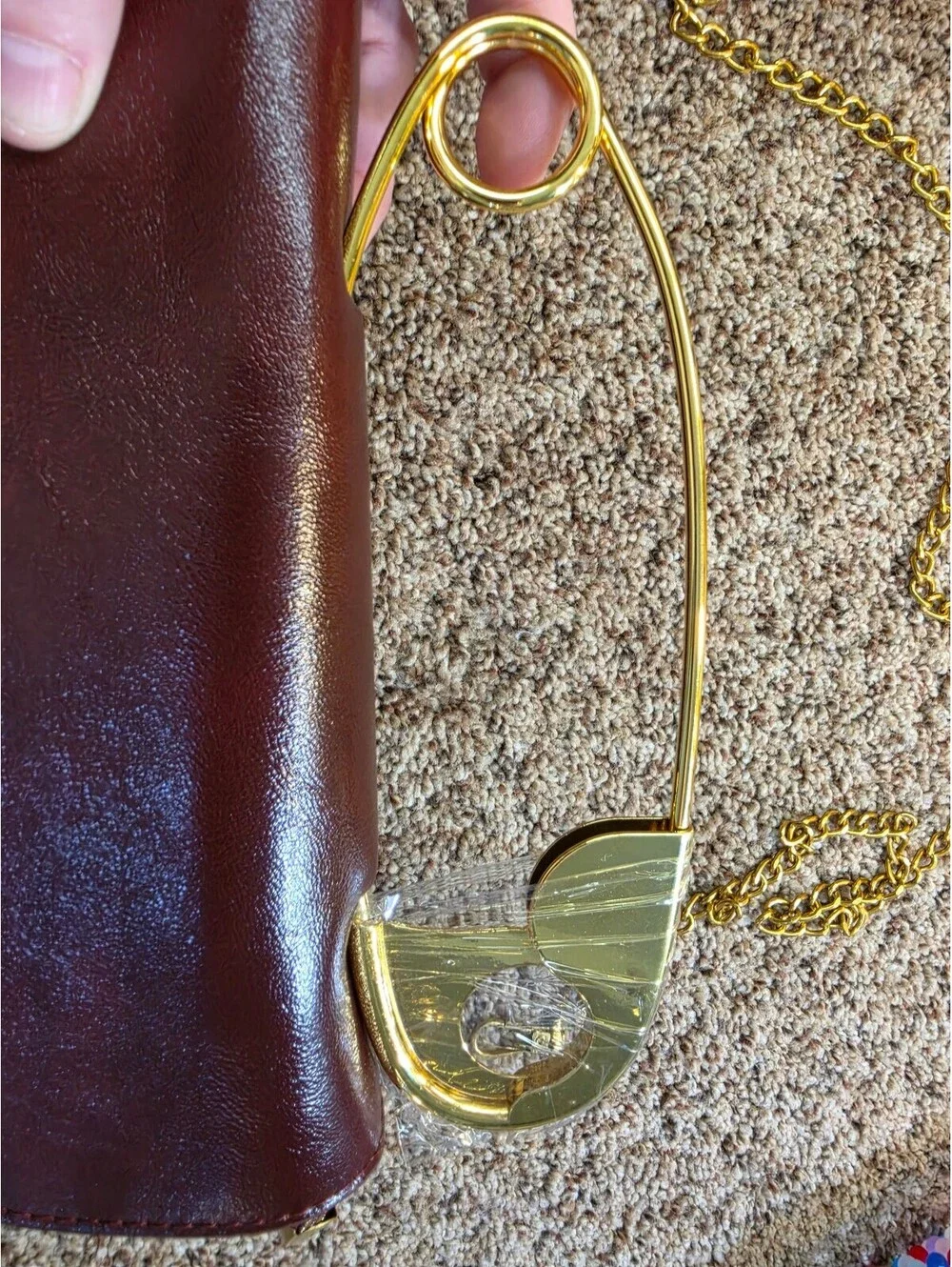 Elegant Burgundy Faux Leather Clutch Bag with Gold Chain and Safety Pin Detail
